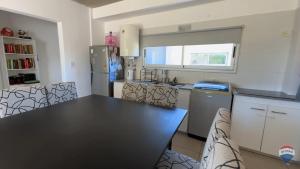 een keuken met een zwarte tafel en stoelen bij Homero duplex in Villa Gesell