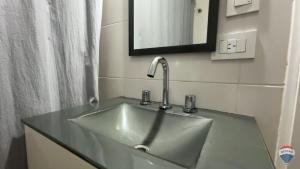 een wastafel in een badkamer met een spiegel bij Homero duplex in Villa Gesell