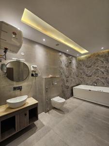 een badkamer met een wastafel, een toilet en een bad bij Riverside Bliss at Sukoon - Private Ganga Ghat & Aarti in Haridwār