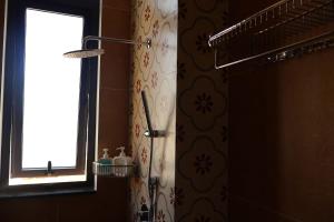 a bathroom with a shower with a mirror and a window at Prova Home in Da Lat