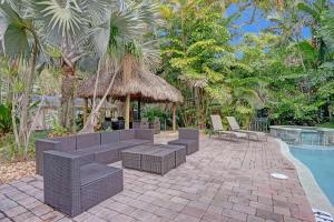 a patio with wicker furniture next to a swimming pool at Tropical Oasis Studio w Pool in Fort Lauderdale