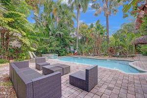 a swimming pool with wicker chairs and a table and a swimming pool at Tropical Oasis Studio w Pool in Fort Lauderdale