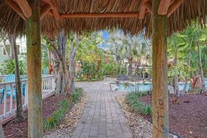a pathway leading to a resort with a straw umbrella at Tropical Oasis Studio w Pool in Fort Lauderdale +42 photos