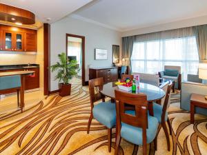 een woonkamer met een tafel en een eetkamer bij Grand Mercure Majlis Residences Abu Dhabi in Abu Dhabi
