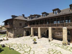 a large brick building with a deck and a patio at Casa de Abril 1 in San Cristóbal de Valdueza