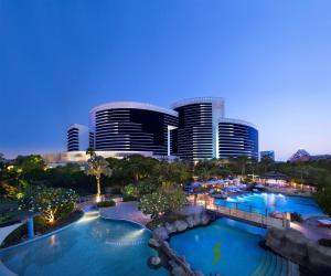 a view of a hotel with two pools and a city at Grand Hyatt Dubai Resort & Waterpark in Dubai