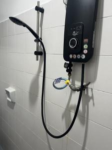 een douchekop met een slang aan een muur bij LIY Homestay in Gua Sai