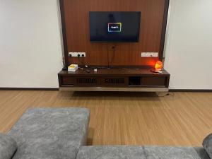 een woonkamer met een tv en een bank bij LIY Homestay in Gua Sai