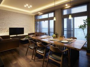 een eetkamer met een grote houten tafel en stoelen bij Minn Chitose in Chitose