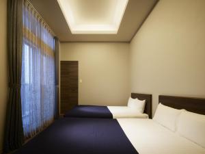 een kleine slaapkamer met een bed en een raam bij Minn Chitose in Chitose