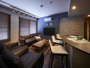 een woonkamer met een bank en een tafel bij Minn Chitose in Chitose