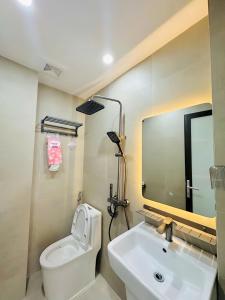 a bathroom with a toilet and a sink and a mirror at Cozy Homestay Tây Mỗ in Phú Thú