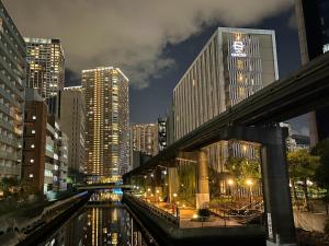 a city at night with a river and buildings at Hotel Gracery Tokyo Tamachi in Tokyo