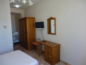 a bedroom with a bed and a desk with a television at Hotel Antequera Rural Fortes La Nuit in Mollina