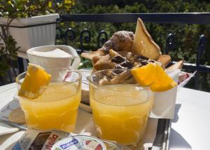 a tray with two glasses of orange juice and a plate of food at Bougainvillea Relais in Sorrento