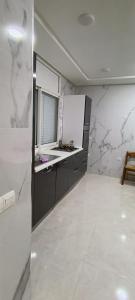 een keuken met witte marmeren muren en een aanrecht bij Temara wifak in Temara +3 foto's