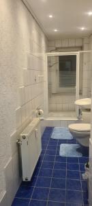 ein Badezimmer mit 2 Waschbecken und einer Dusche mit blauen Fliesen in der Unterkunft Merci Sweet Home in Niestetal + 21 Fotos