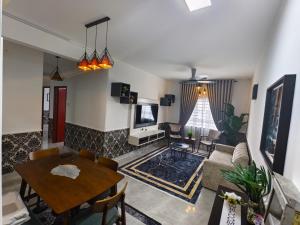 a living room with a table and a couch at Cocasa Homestay 1 in Kuala Terengganu