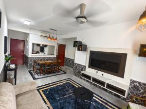 a living room with a couch and a television at Cocasa Homestay 1 in Kuala Terengganu +9 photos