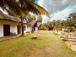 a house with a grass yard next to a building at Kiteclub in Kalpitiya +18 photos