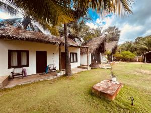 a house with a grass yard with a table in front of it at Kiteclub in Kalpitiya