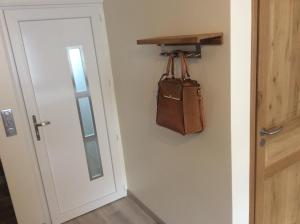 een tas hangend aan een muur naast een deur bij Appart Hôtel l'Orchidée in Morangis