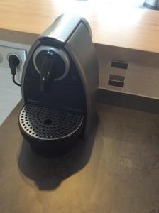 uma máquina de café sentada em cima de uma mesa em Appart Hôtel l'Orchidée em Morangis