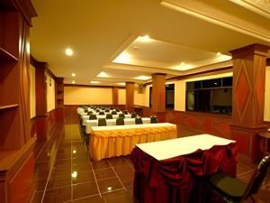 une salle de banquet avec des tables et des chaises dans une pièce dans l'établissement Phuthong Place, à Phayao