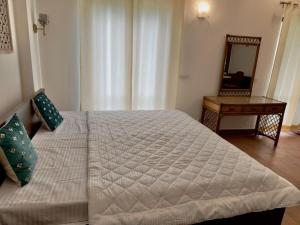 a bedroom with a bed with a mirror and a table at Minimalist Escape in Gurgaon