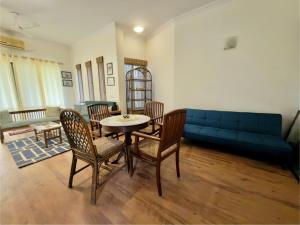 a living room with a blue couch and a table and chairs at Minimalist Escape in Gurgaon