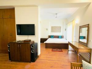 a living room with a bed and a television at Minimalist Escape in Gurgaon