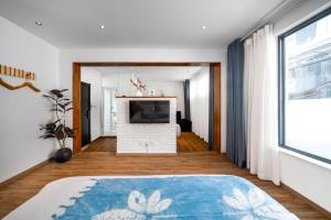 a living room with a fireplace and a television at 叁三民宿 in Dali