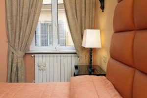 ローマにあるRome in your heart - Spagna apartmentのベッドルーム(ベッド1台、窓、ランプ付)