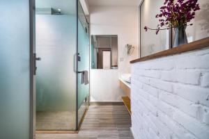 a bathroom with a glass shower and a white brick wall at 叁三民宿 in Dali +71 photos