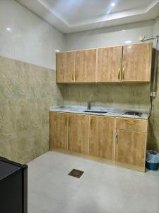 a kitchen with wooden cabinets and a sink at فندق جراند روز in Najran +32 photos