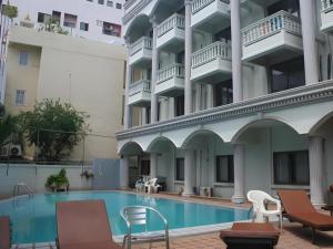 a swimming pool in front of a building at Honey Lodge in Pattaya South