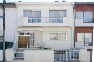 Biały dom z bramą i balkonem w obiekcie Burgo's House w Porto