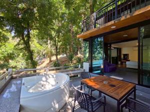 a bath tub on a patio with a table and chairs at Puprai Tarnnarm Resort in Thong Pha Phum
