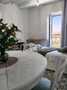 een kamer met een tafel, een bed en een raam bij La Casetta nel Borgo in Cerisano