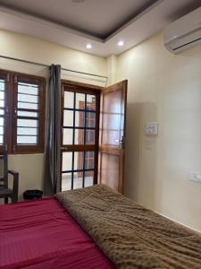 een slaapkamer met een groot bed en een raam bij Hathayogashram Hostel in Rishīkesh