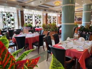 a restaurant with tables and chairs with red table cloth at Kabul Star Hotel & Restaurant in Shīrpūr