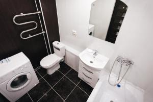 a white bathroom with a toilet and a sink at Apartment 2Pillows Vorovskogo in Vologda