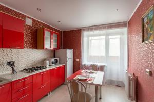 a kitchen with red cabinets and a white refrigerator at Apartment 2Pillows Vorovskogo in Vologda