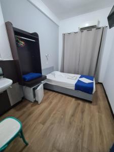 una piccola camera da letto con un letto e un lavandino di Sparta Team Hotel ad Atene Altre 59 foto