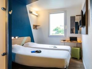 a hotel room with two beds and a window at ibis budget Orly Rungis in Rungis +31 photos