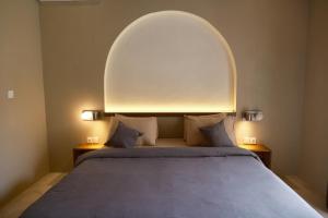 una camera da letto con un grande letto con un arco sopra di esso di Avaya Boutique Hostel by Ayodya Beach Inn a Legian