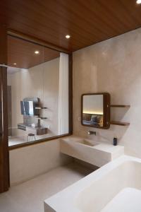 un bagno con lavandino e specchio di Avaya Boutique Hostel by Ayodya Beach Inn a Legian Altre 17 foto