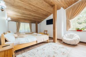 a bedroom with a large bed with a wooden ceiling at Cabana Gura Voronețului in Gura Humorului