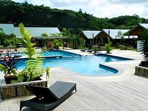 SiusegaOrator Hotel的度假村里的泳池，配有黑色椅子