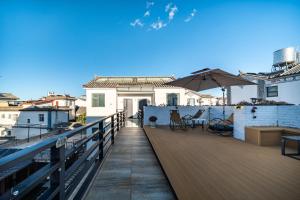 a balcony with chairs and an umbrella on a building at 叁三民宿 in Dali